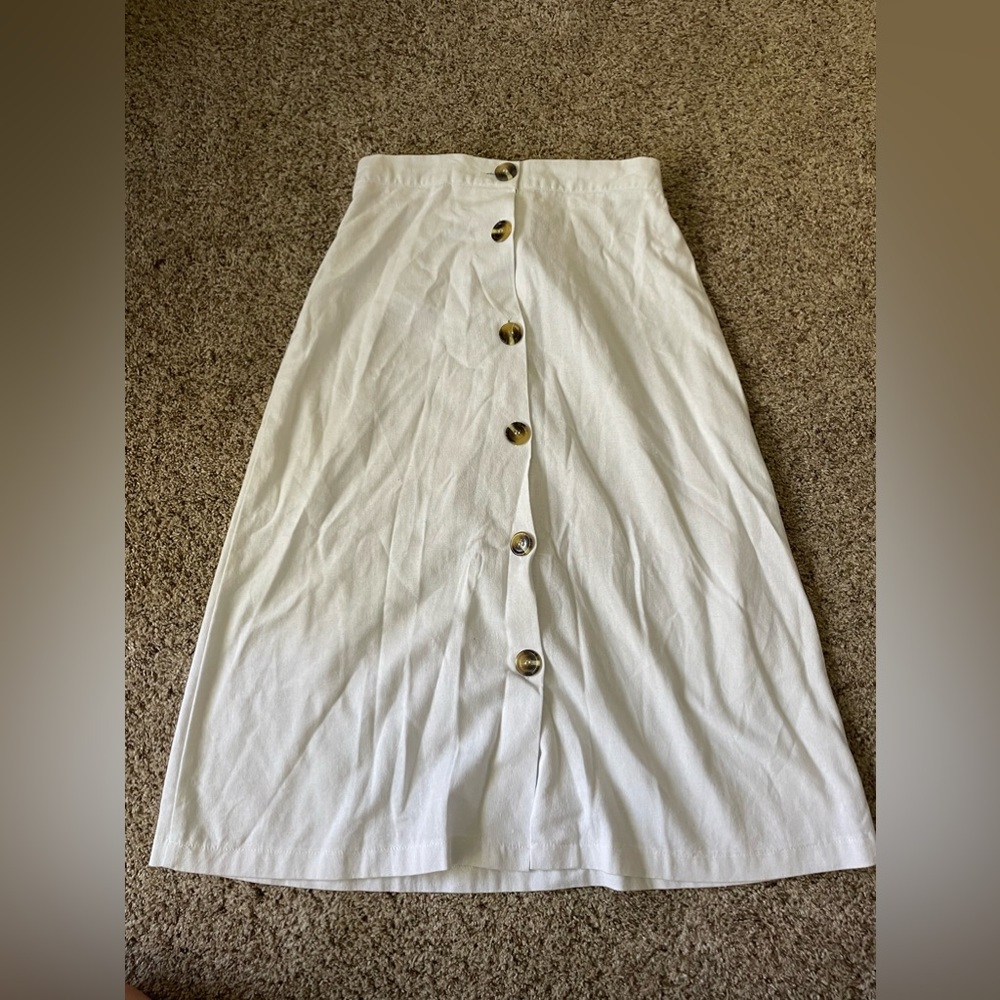 White skirt with buttons.